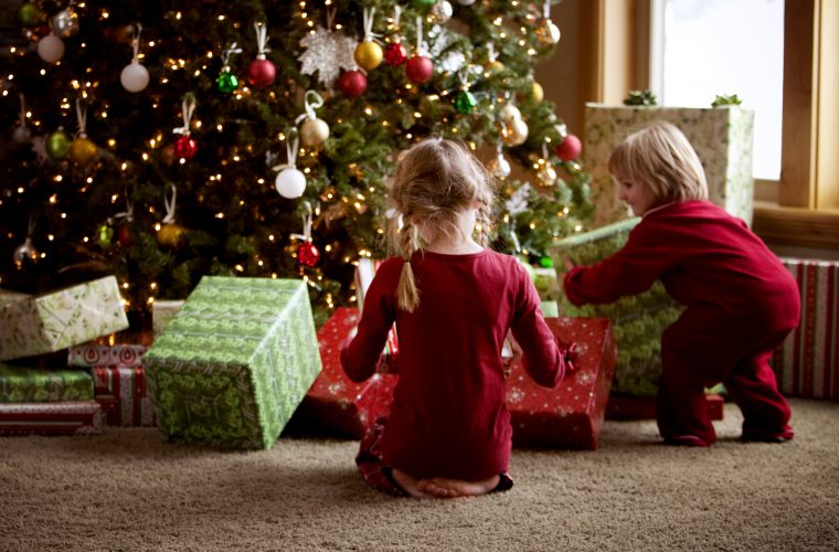 two children opening gifts on christmas morning